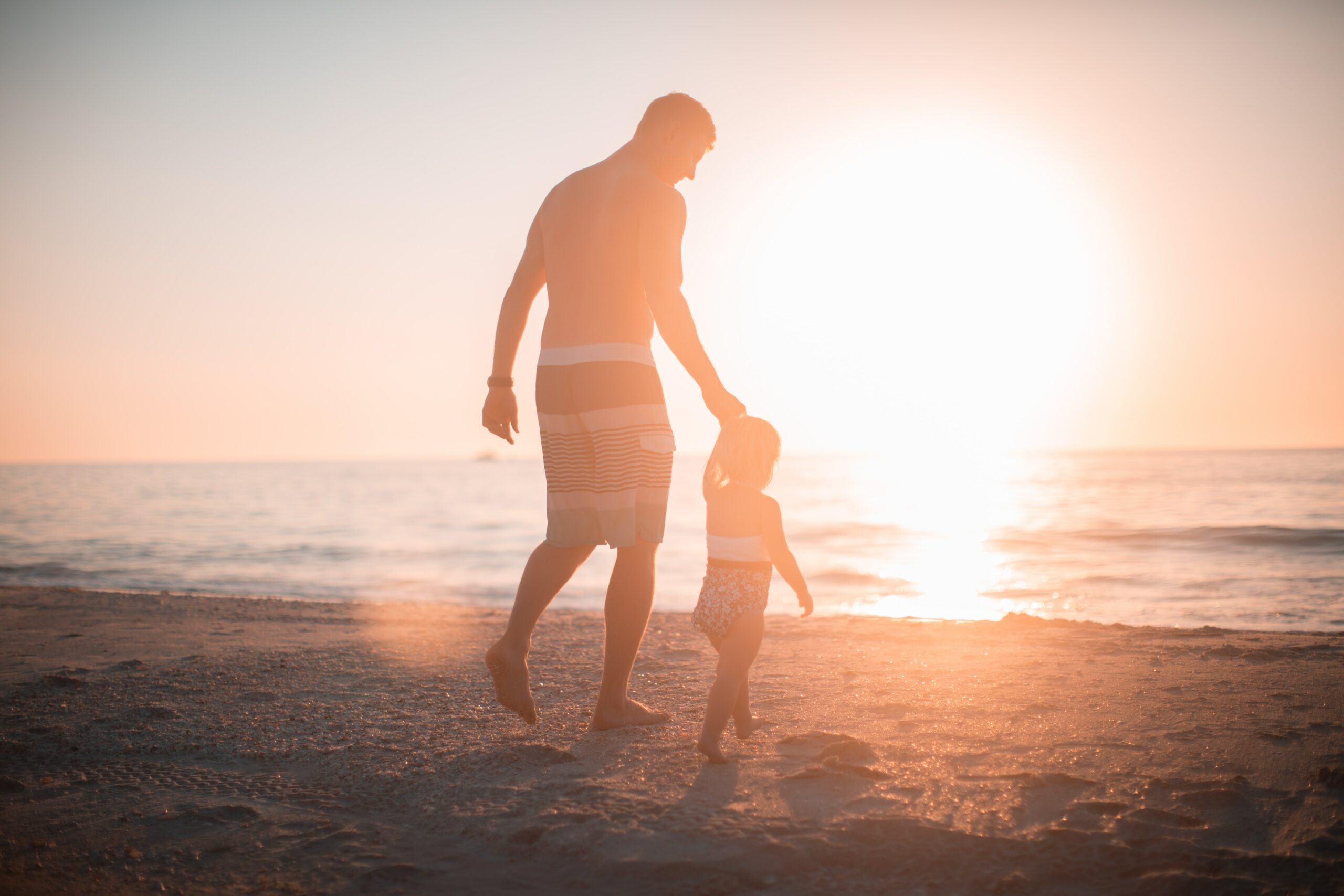 padre e figlia in spiaggia al tramonto